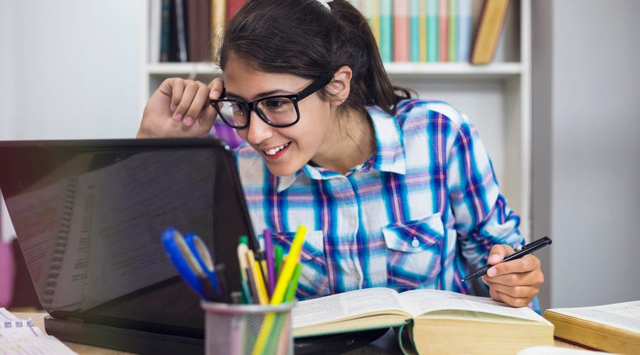 Niña leyendo sobre ¿Cuál es la mejor edad para las clases de inglés para niños?
