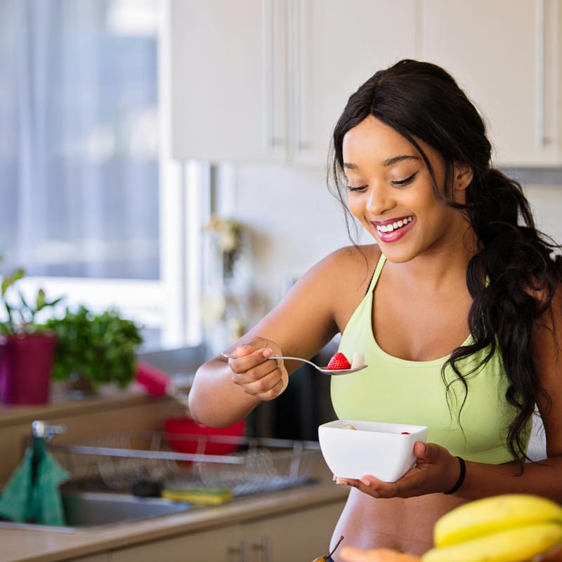 Mujer con un bowl de frutas para empezar sus hábitos saludables.