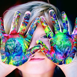 Un niño con las manos pintadas de colores