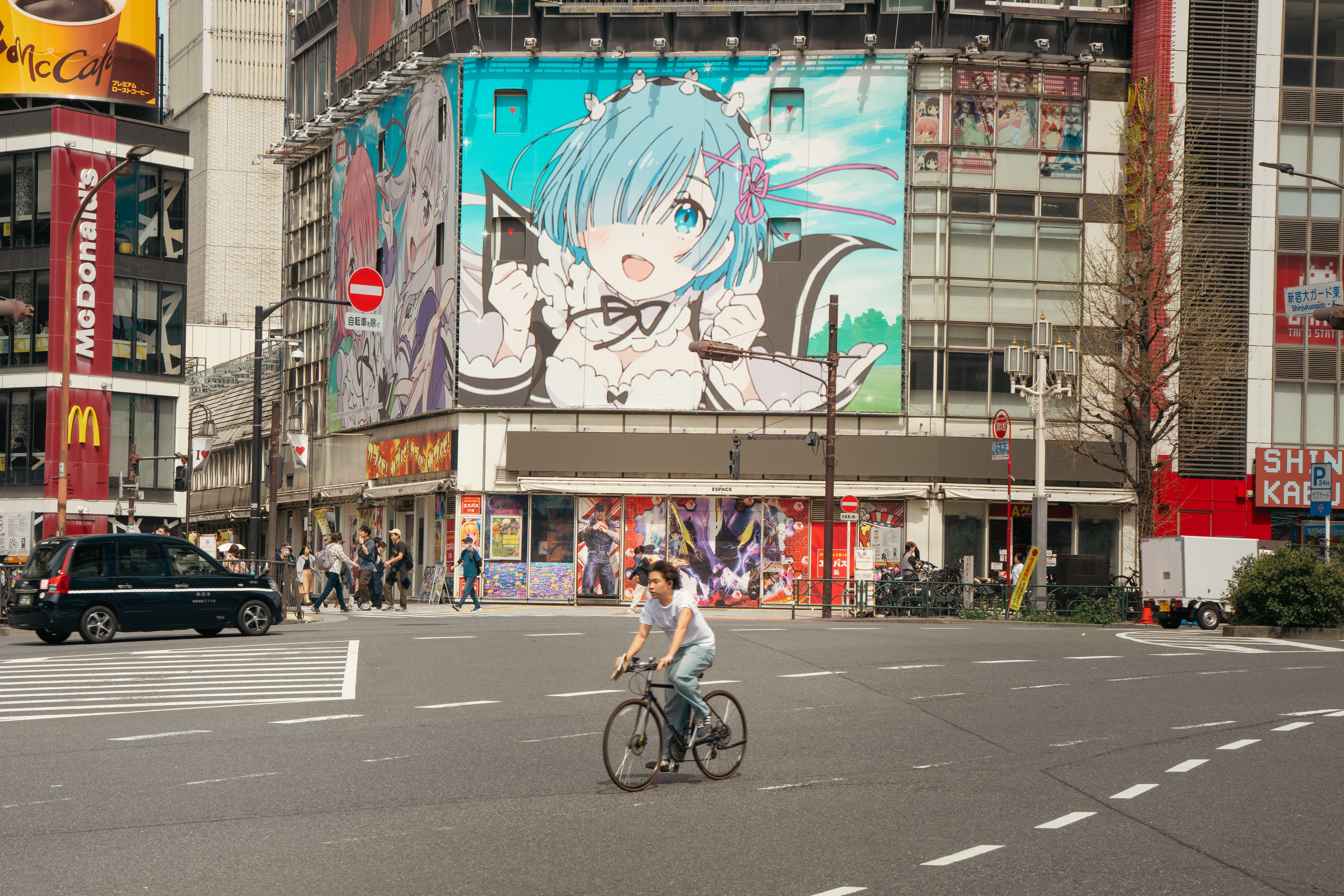 Calle en Japón con un dibujo de anime en un edificio para representar la cultura pop.