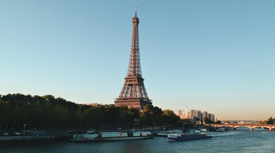 París de día, con el río y la Torre Eiffel al fondo, el destino perfecto para aprender hablar francés.