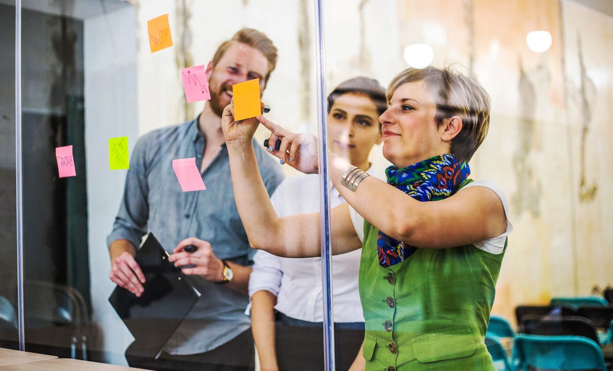 Mujer señalando ideas en una dinámica grupal para aprender idiomas con expertos de Berlitz