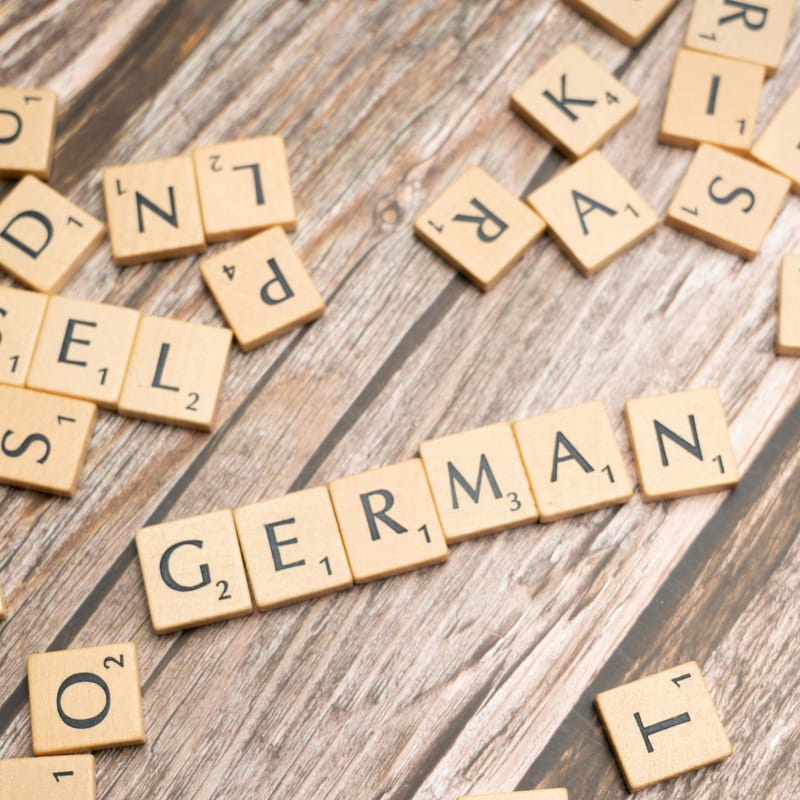 Letras de Scrabble que deletrean la palabra "German" para representar el tema de hablar alemán.