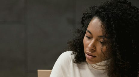 Mujer leyendo un libro de inglés para su clase.