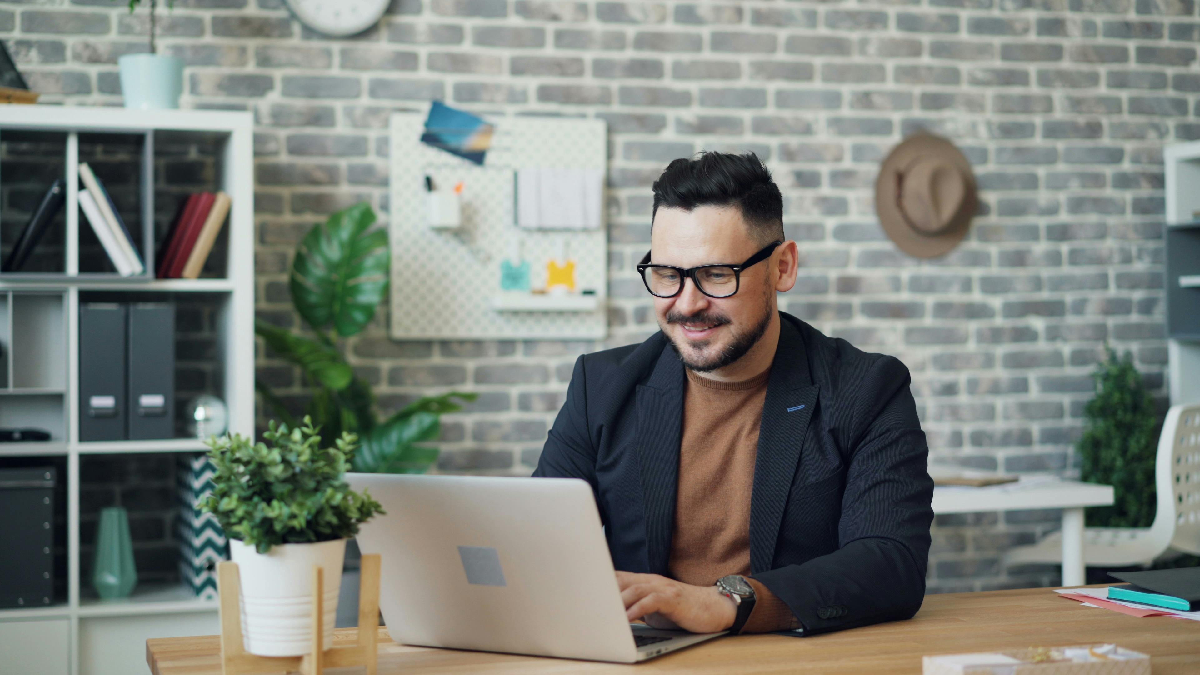 Hombre trabajando con su computadora en el teletrabajo.