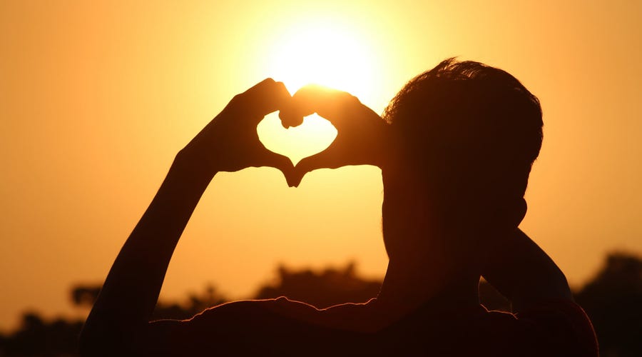 Un hombre haciendo con las manos la forma de un corazón
