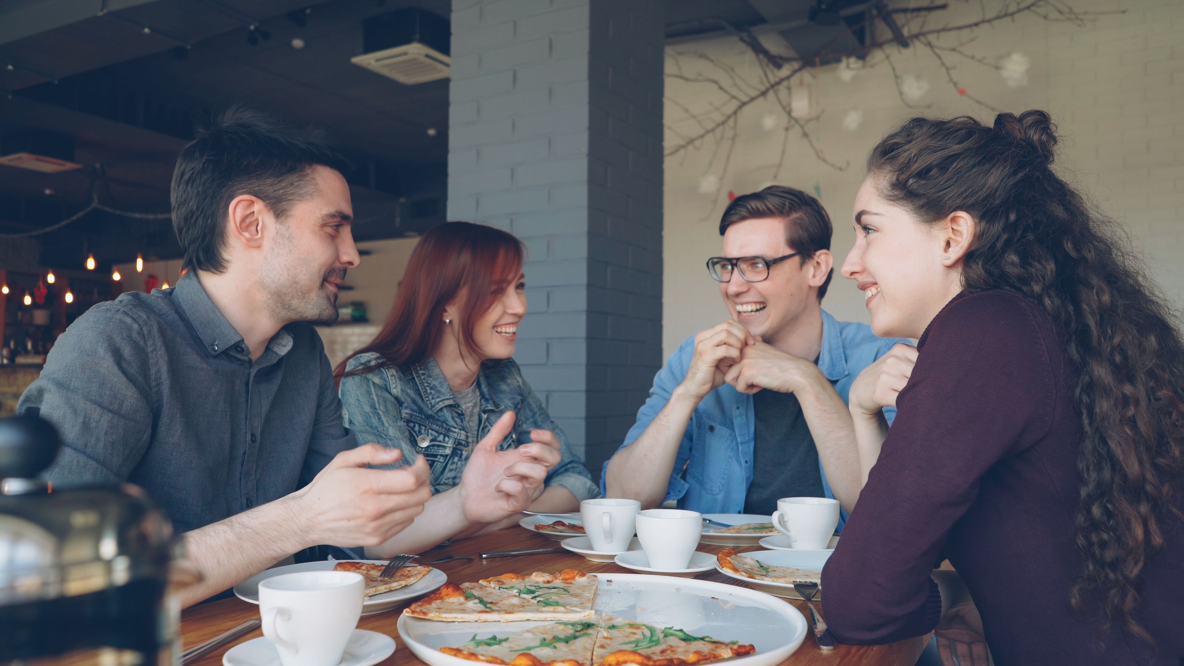 Un grupo de amigos hablando sobre personalidad mientras comen pizza.