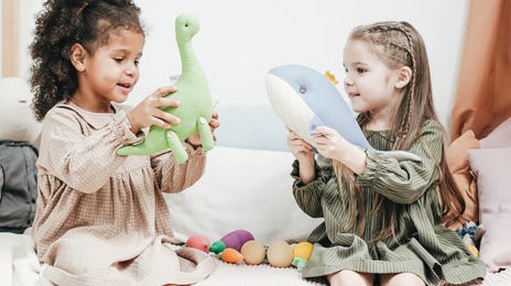 Dos niñas jugando con muñecos de peluche