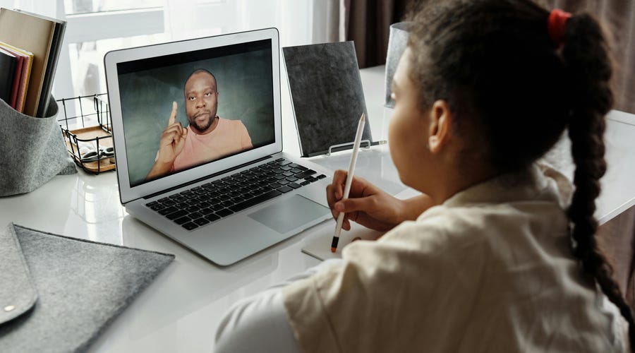 Niña estudiando con su profesor para examen de inglés.