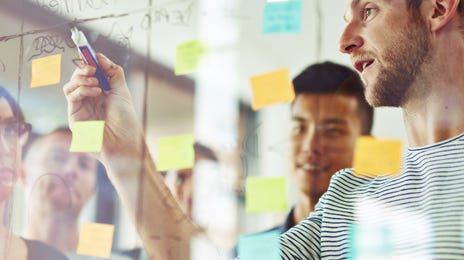 Dos estudiantes trabajando en un pizarrón
