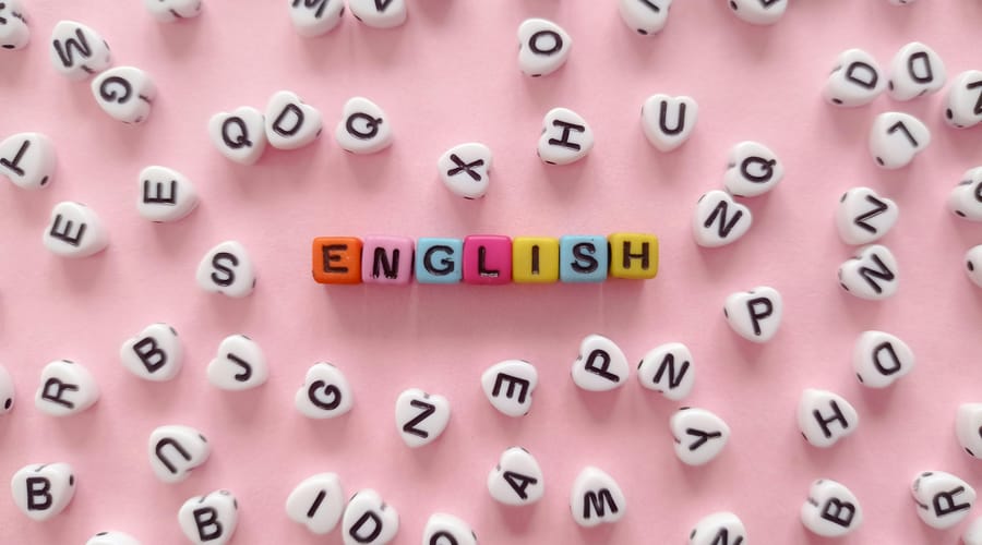 La palabra “English” formada por letras en desorden sobre un fondo rosa.