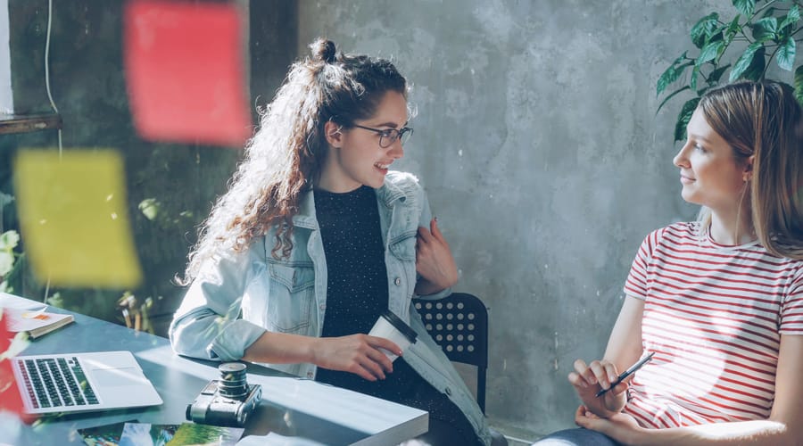 Dos mujeres hablando sobre la diferencia entre introvertido y extrovertido en el aprendizaje.