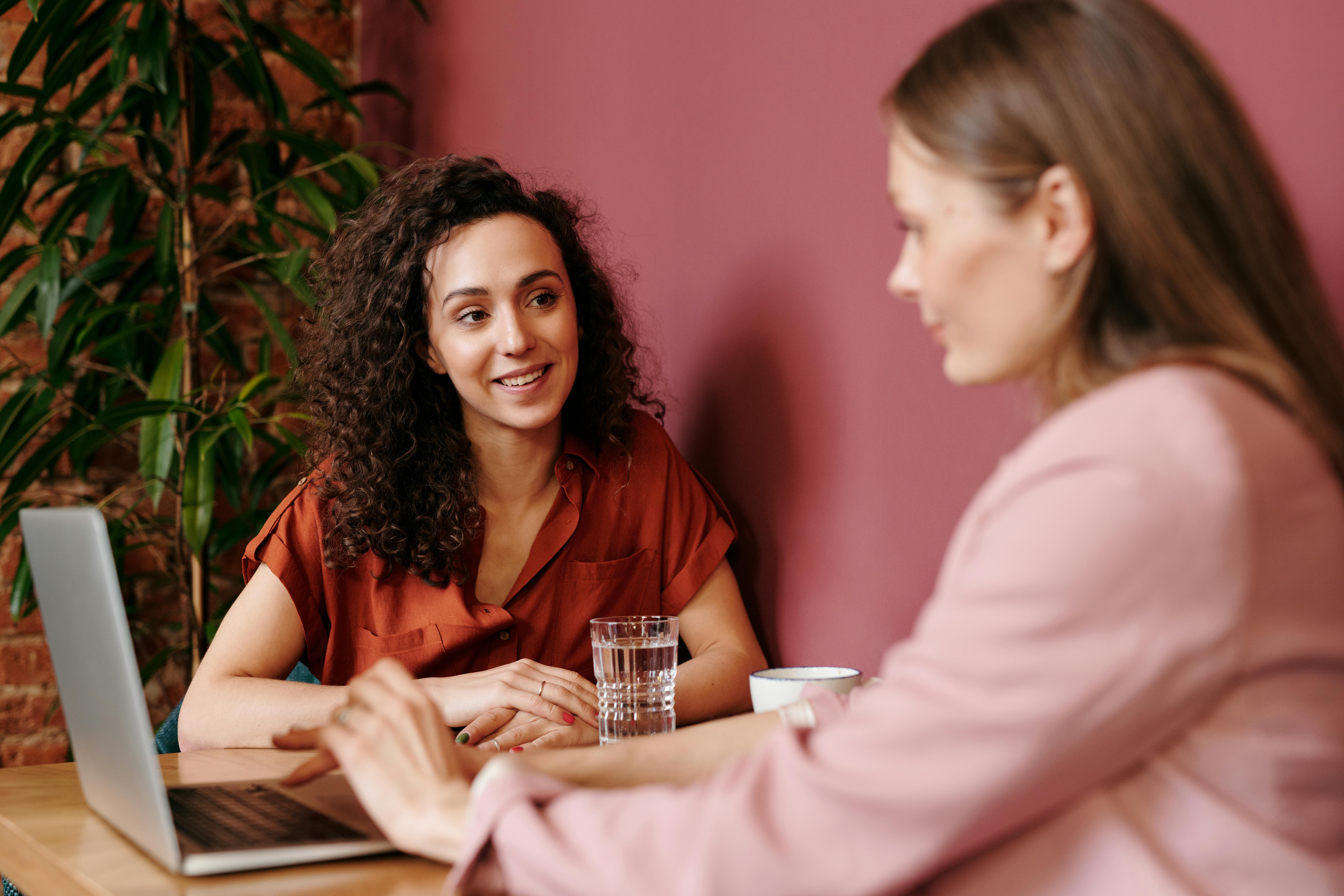 Dos mujeres sentadas frente a una mesa de estudio, ambas están estudiando sobre habilidades cognitivas.