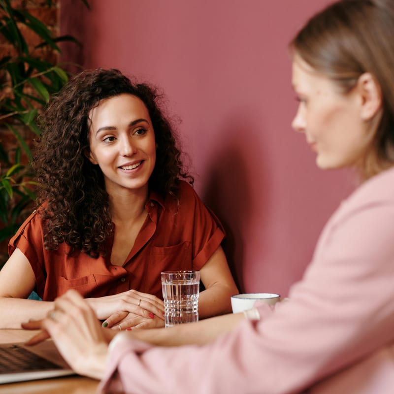 Dos mujeres sentadas frente a una mesa de estudio, ambas están estudiando sobre habilidades cognitivas.