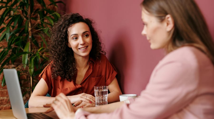 Dos mujeres sentadas frente a una mesa de estudio, ambas están estudiando sobre habilidades cognitivas.