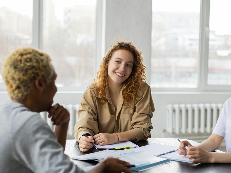 Tres amigos estudiando juntos los adverbios de lugar en inglés.