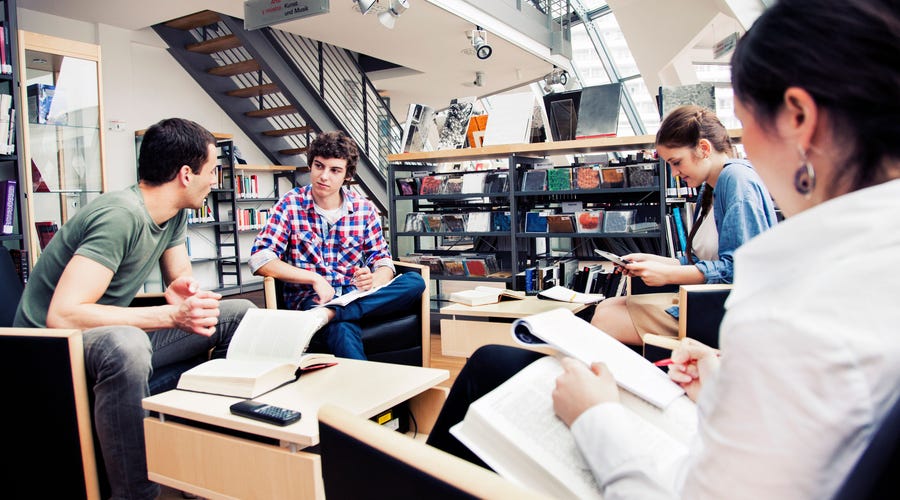 cuatro jóvenes en una biblioteca