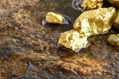 Chunks of gold sitting on a rock