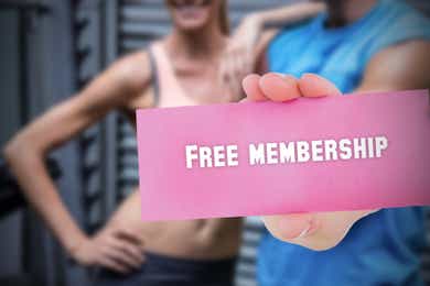 The words free membership on a pink card and woman a and a man at a gym