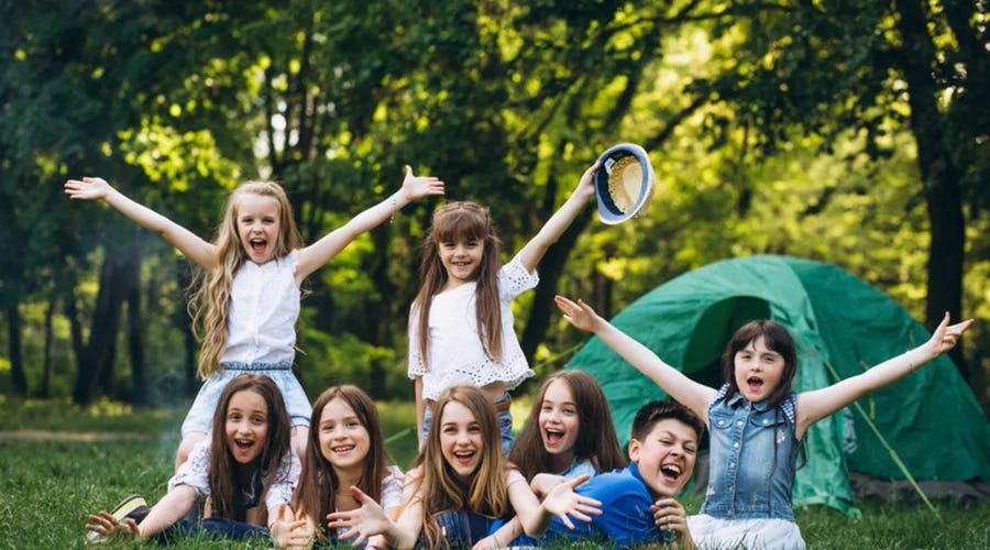Niños felices jugando en campamento, aprendizaje de idiomas divertido y al aire libre con Berlitz.