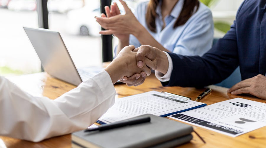 Personas en reunión de negocios estrechando manos, éxito profesional gracias a Berlitz.