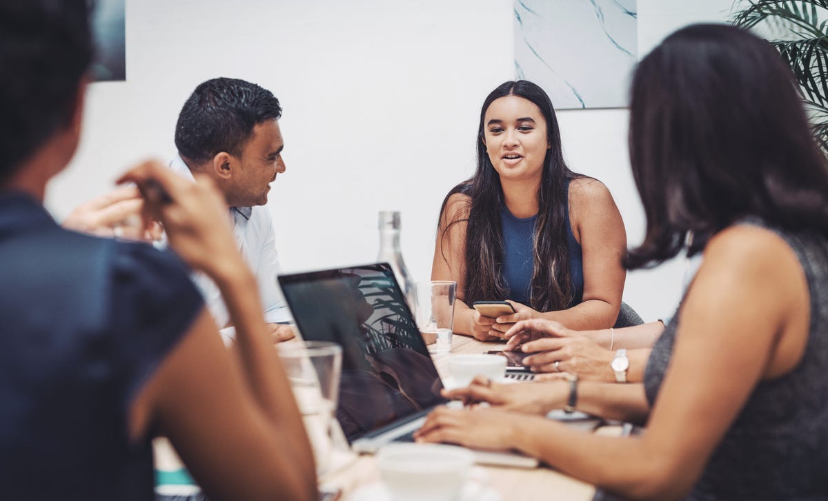 Un grupo de profesionales que conversa y colabora en una mesa de reuniones.