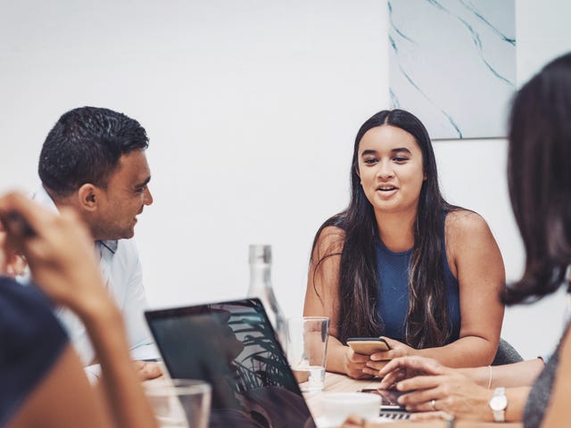 Un grupo de profesionales que conversa y colabora en una mesa de reuniones.