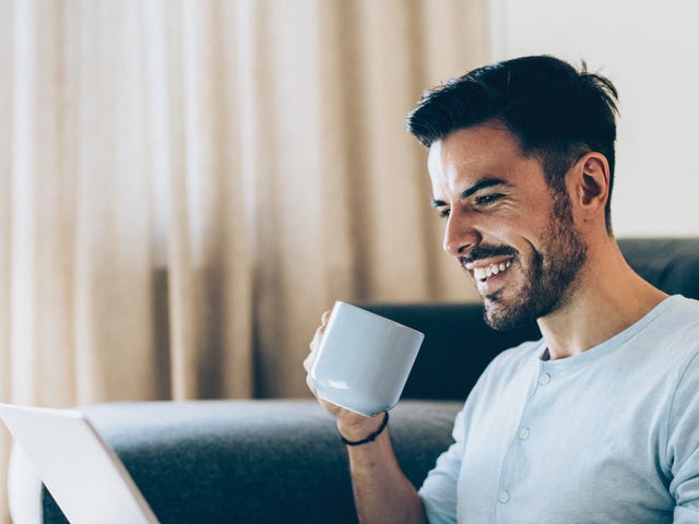 Estudiante de idiomas online Berlitz con café en laptop.