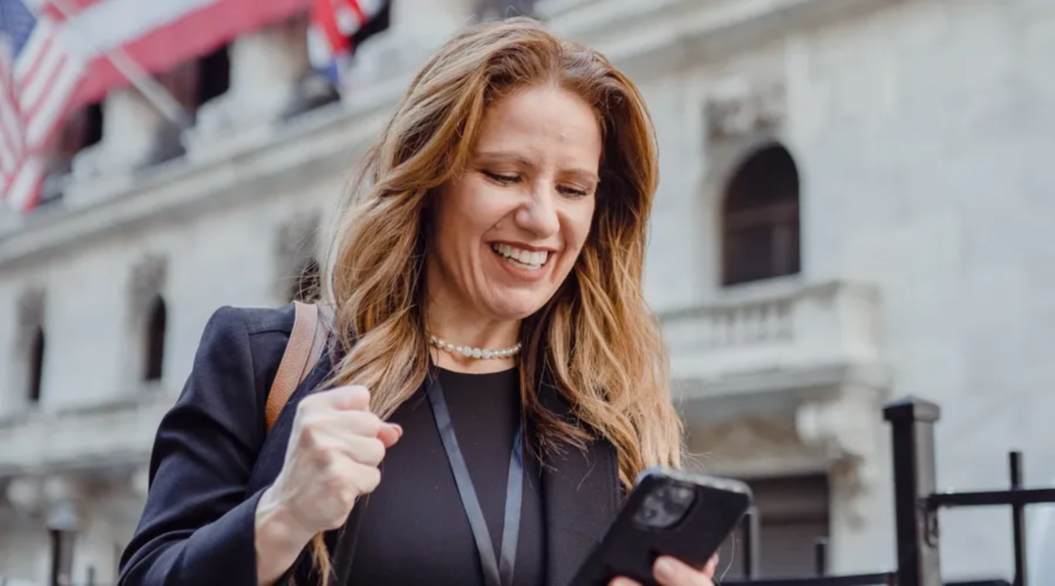 Mujer de negocios celebra éxito, mirando su teléfono, confianza profesional con Berlitz.