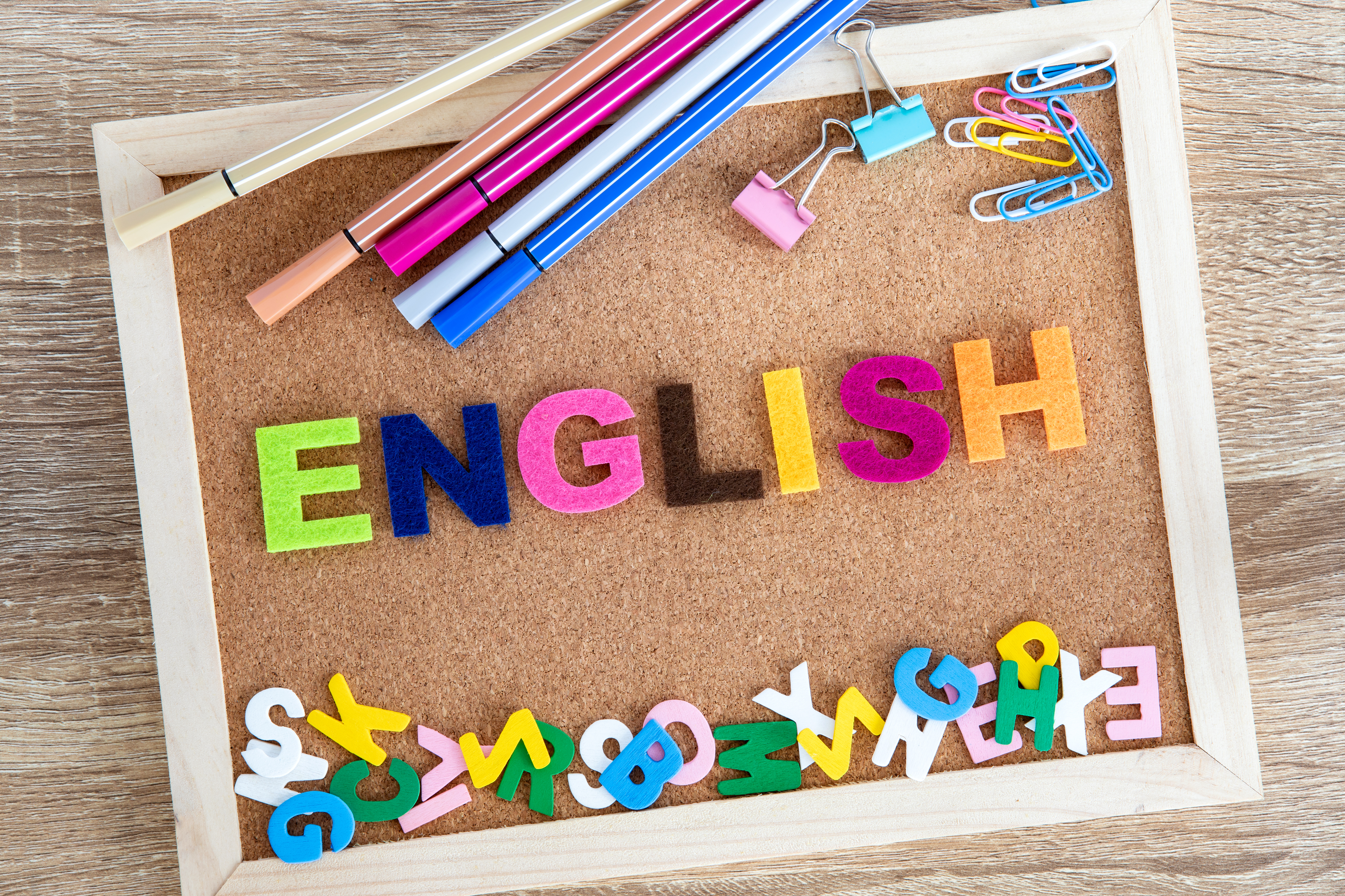 Tablero de corcho con la palabra "ENGLISH" y útiles escolares.