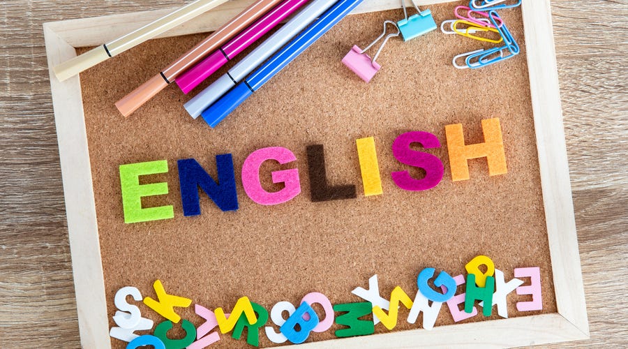 Tablero de corcho con la palabra "ENGLISH" y útiles escolares.