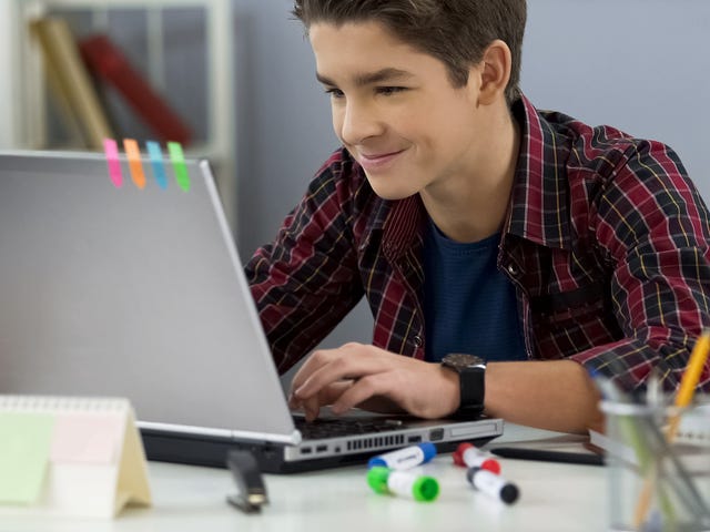Un joven en su laptop, estudiando o entreteniéndose desde su hogar.