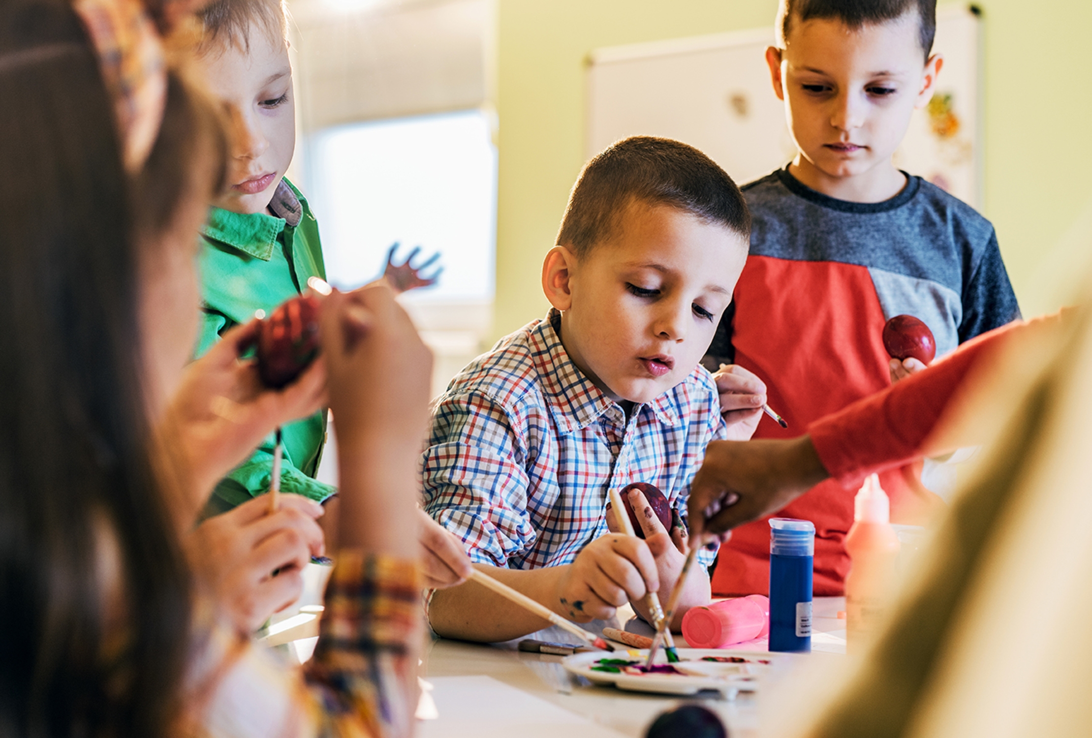 Niños en clase Berlitz pintando, aprendizaje creativo e interactivo.