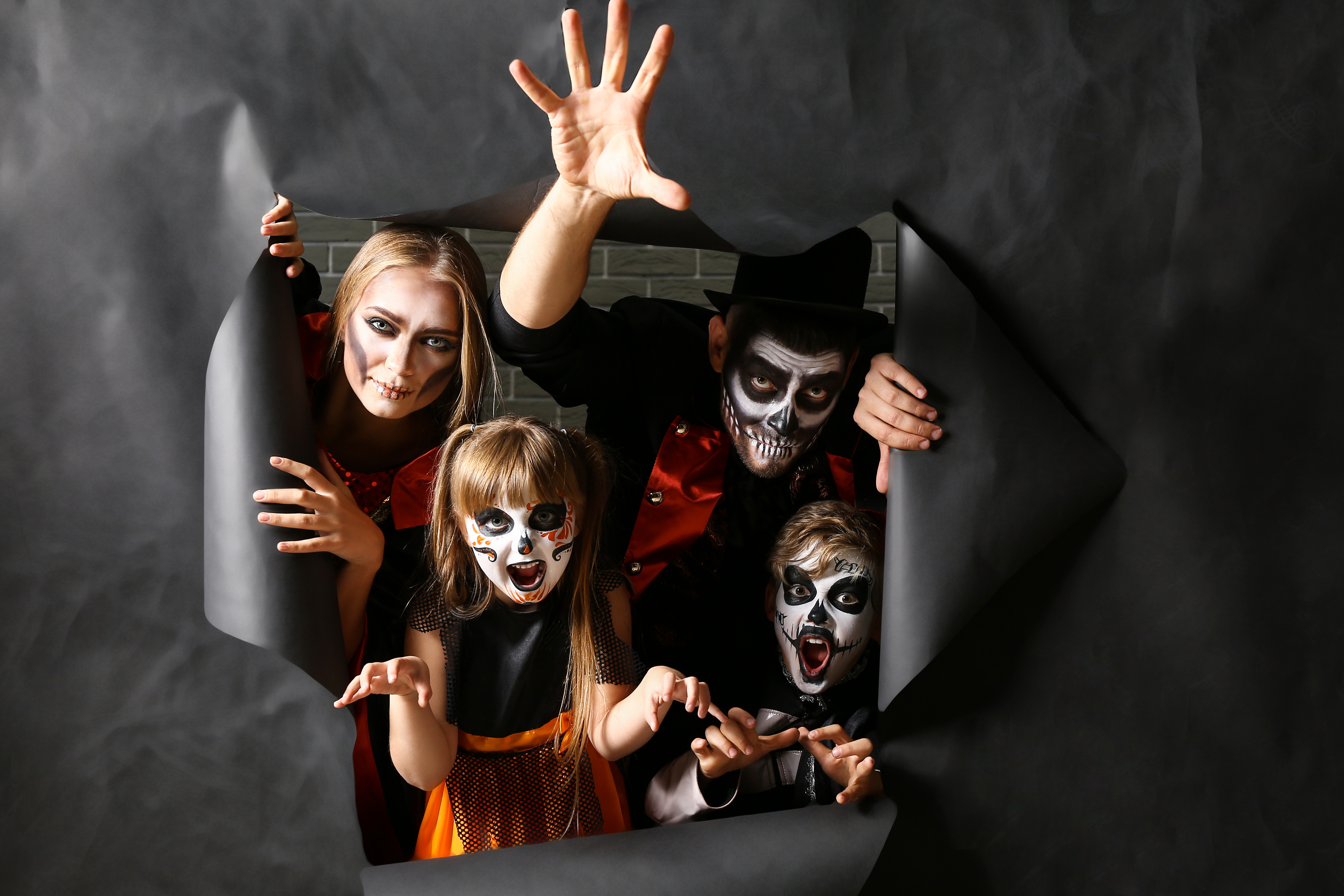 Familia disfrazada de esqueletos para Halloween, celebrando cultura y diversión con Berlitz.