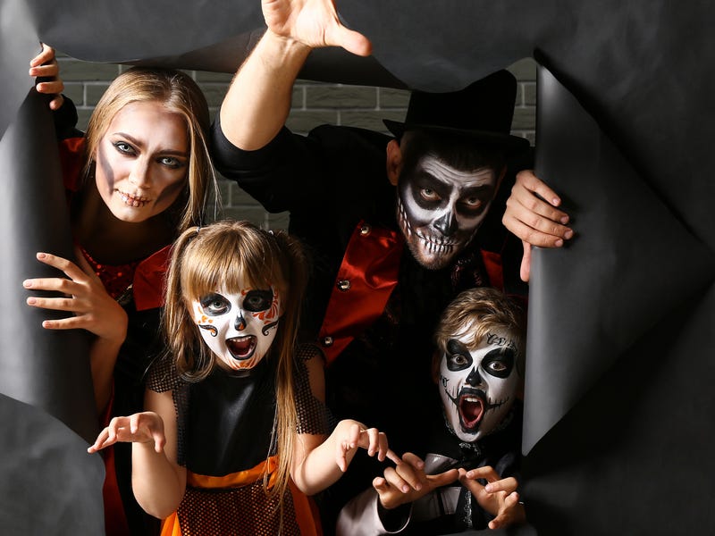 Familia disfrazada de esqueletos para Halloween, celebrando cultura y diversión con Berlitz.