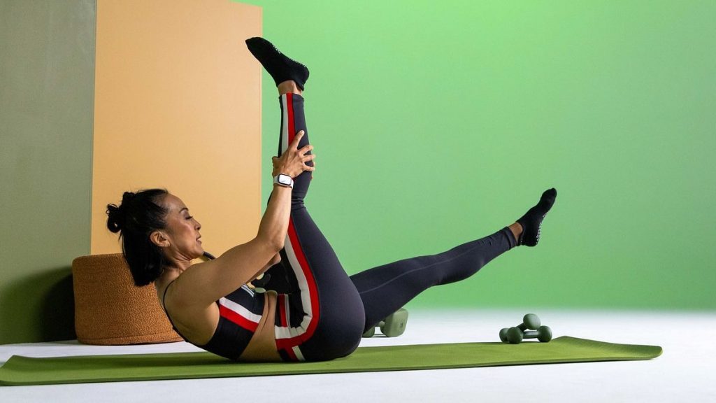 Practitioner performing a mat Pilates core exercise, demonstrating flexibility, balance, and low-impact strength training.