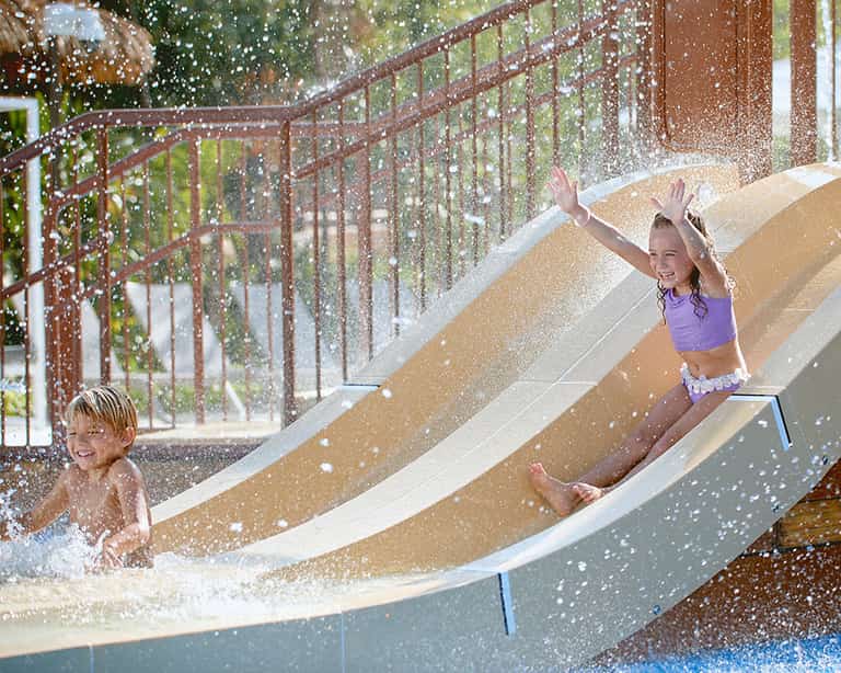 Niña deslizándose por un tobogán en Kids Rain Fortress, Jungala Aqua Experience