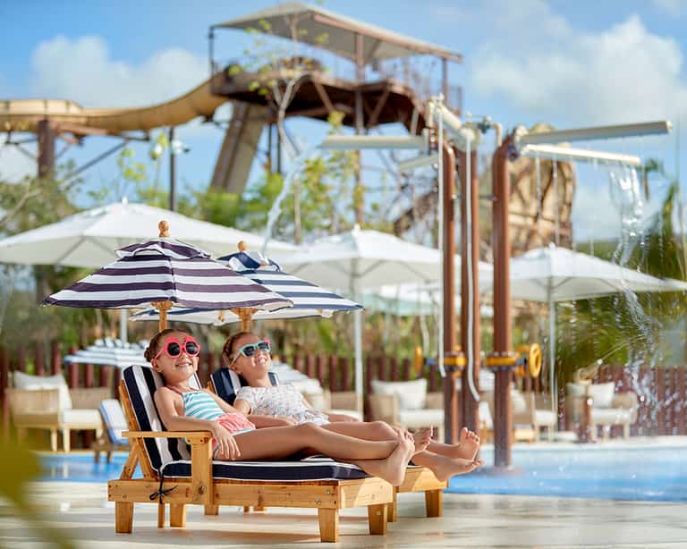 Niñas relajándose en camastros junto al área de Kids Slides, Jungala Aqua Experience