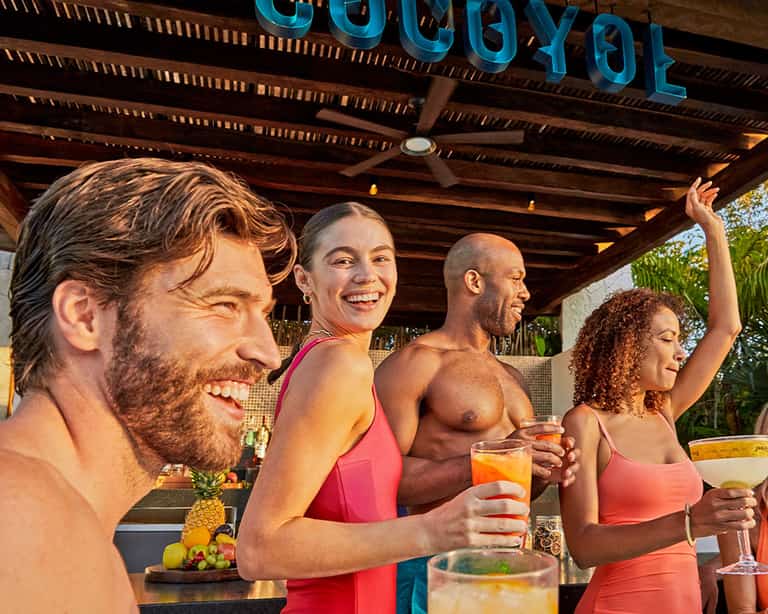 Grupo de amigos conviviendo bajo el letrero de Cocoyol Bar en Jungala Aqua Experience