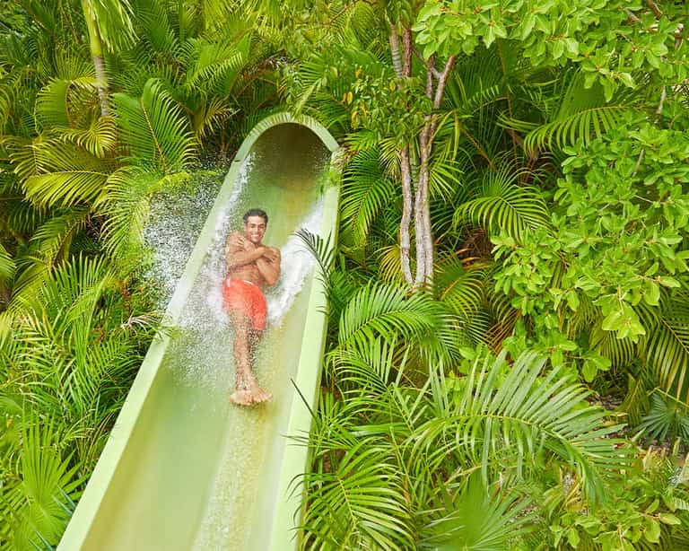 Hombre descendiendo por Selva Loop en Jungala Aqua Experience, rodeado de vegetación tropical