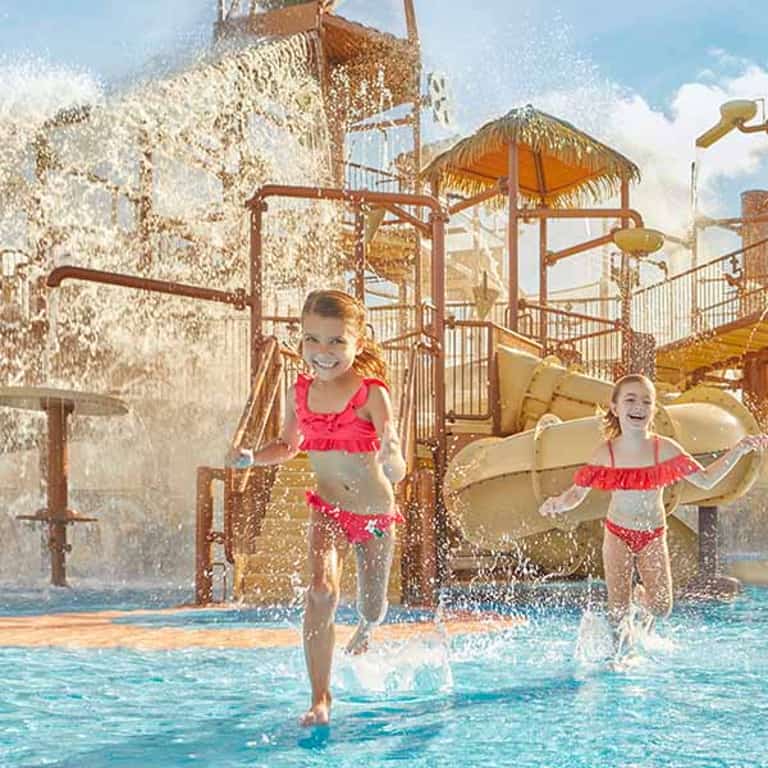 Niñas jugando bajo los chorros de agua de Kids Rain Fortress en Jungala Aqua Experience
