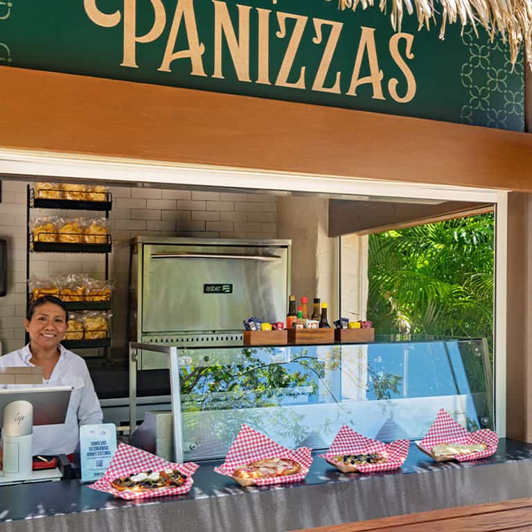 Empleada en la estación de Panizzas de Jungala Aqua Experience, con panizzas recién preparadas