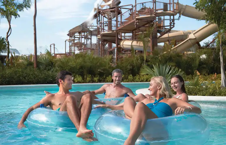 Grupo de amigos recorriendo el Río Lento de Jungala Aqua Experience, con toboganes de fondo