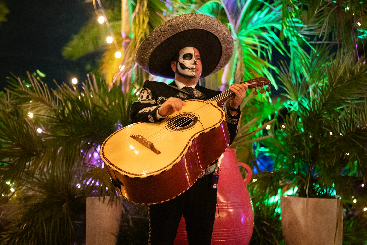 Mariachi in skull makeup playing a guitarrón