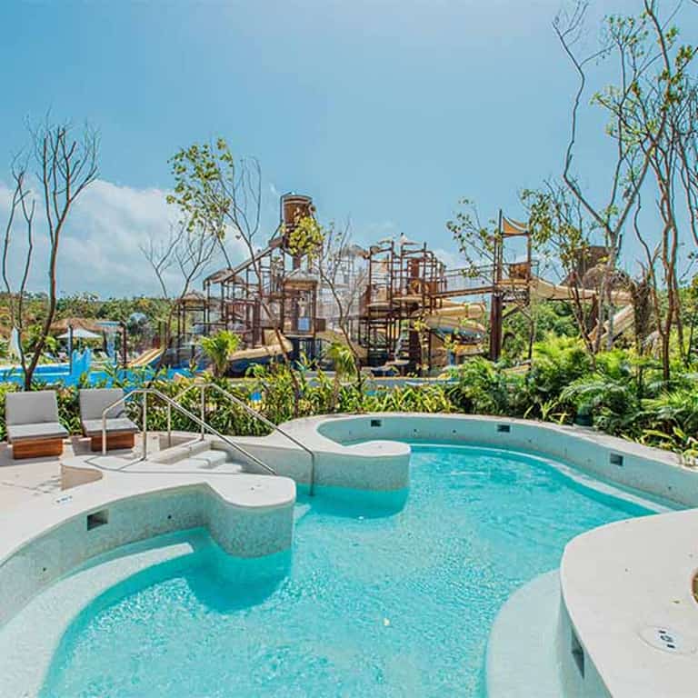 Jacuzzi con camastros en Jungala Aqua Experience, con vista a la zona de toboganes