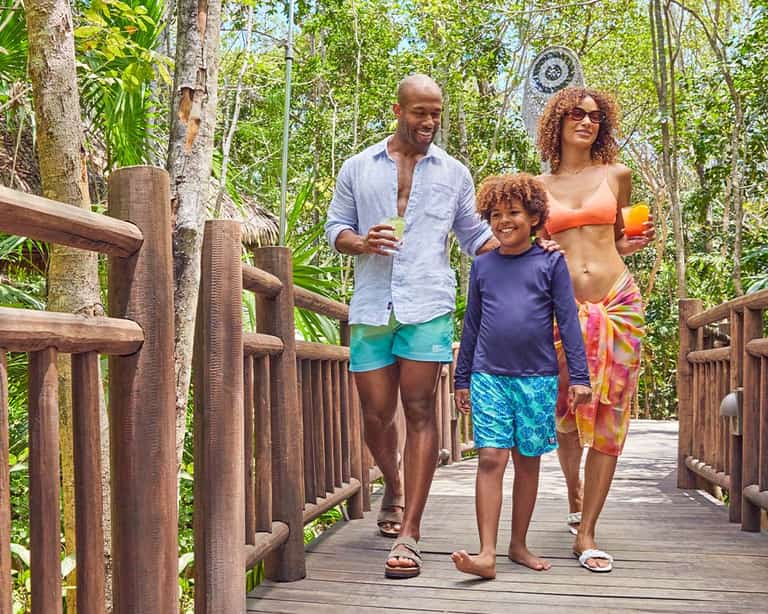 Familia caminando hacia Mojito Bendito en Jungala Aqua Experience, con bebidas en mano