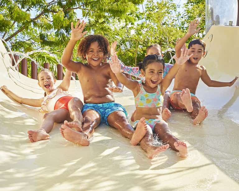 Grupo de niños celebrando al final de un tobogán en el área de Kids Slides, Jungala Aqua Experience