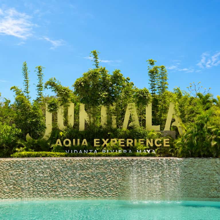 Letrero de Jungala Aqua Experience Vidanta Riviera Maya, rodeado de vegetación y una cascada