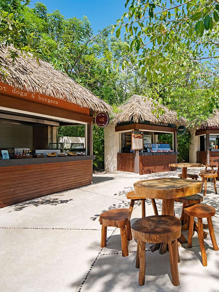 Outdoor food stations surrounded by tropical greenery at Jungala water park