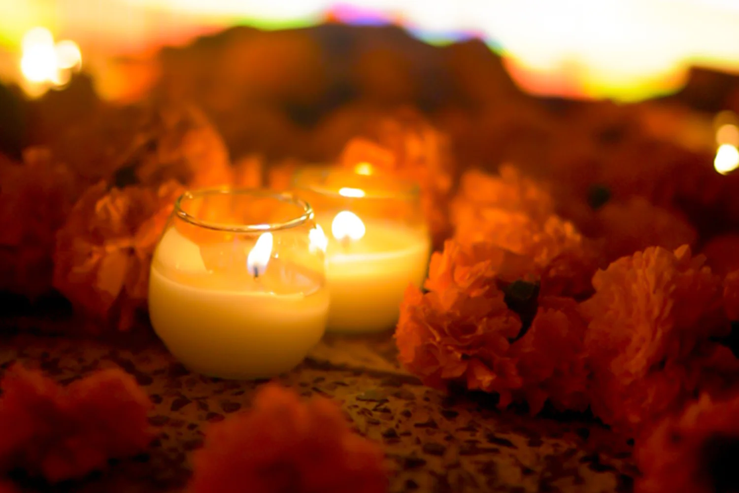 Candles glowing among marigold petals